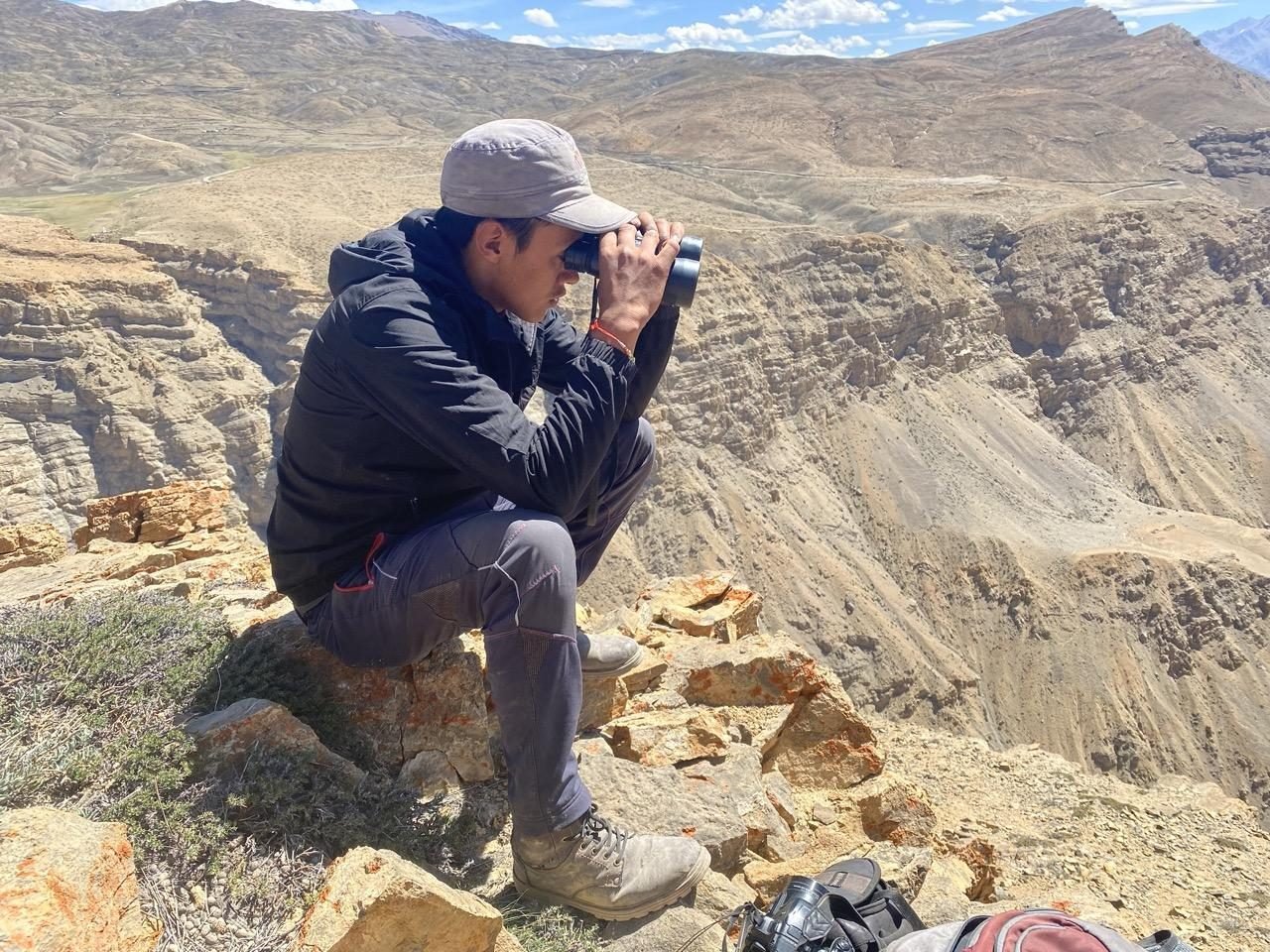 Tashi scanning the Spiti gorge through binoculars